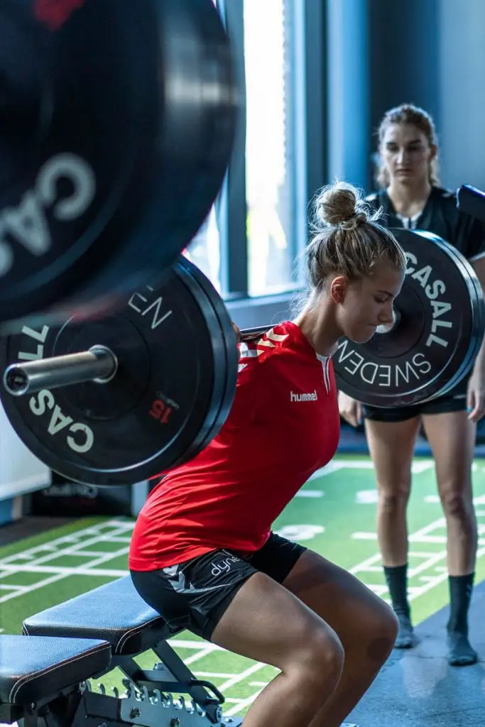 Kvinne trener med vekter hos Sterkere trening