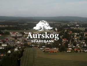 Aurskog Sparebank logo med bebyggelse i bakgrunnen