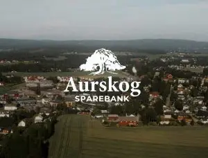 Aurskog Sparebank logo med bebyggelse i bakgrunnen